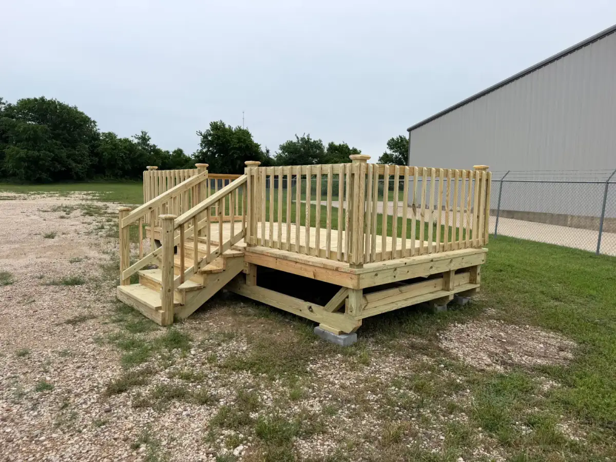 Custom pressure-treated pine deck with railing and stairs built by BenchMark Decks