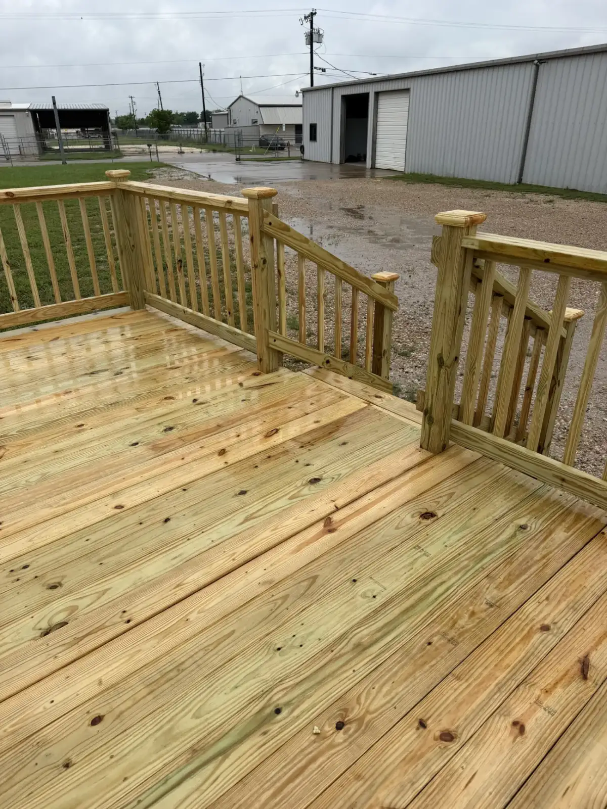 Wide-plank pine deck surface with railing detail